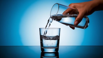 pouring-water-into-glass-blue-background_926199-2341487
